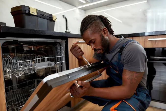Technician inspecting the door panel of a dishwasher