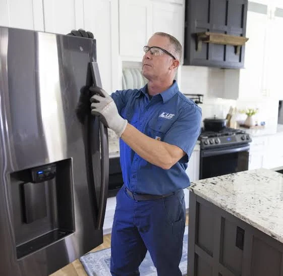 Technician wearing gloves inspecting a refrigerator door